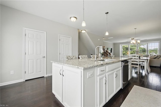 kitchen featuring dark wood-style flooring, dishwasher, a sink, open floor plan, and white cabinetry