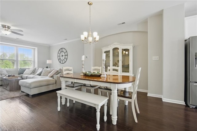 dining area featuring visible vents, crown molding, baseboards, dark wood-style floors, and ceiling fan with notable chandelier