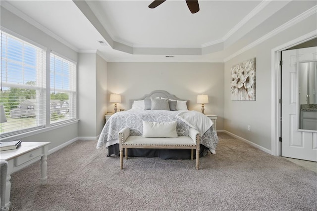 bedroom featuring carpet flooring, a tray ceiling, crown molding, and baseboards