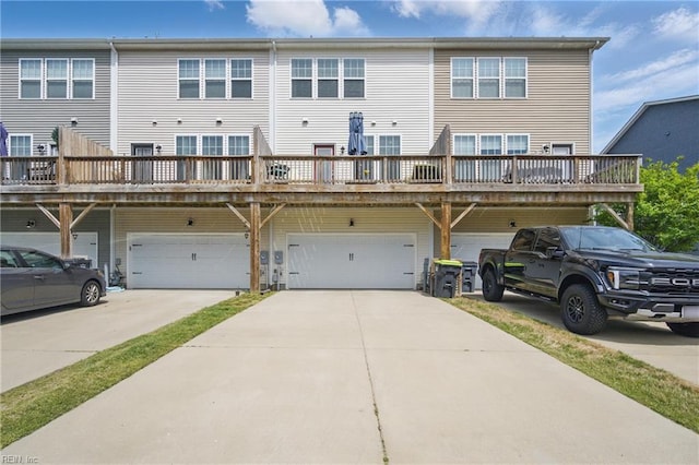 rear view of house with an attached garage and driveway