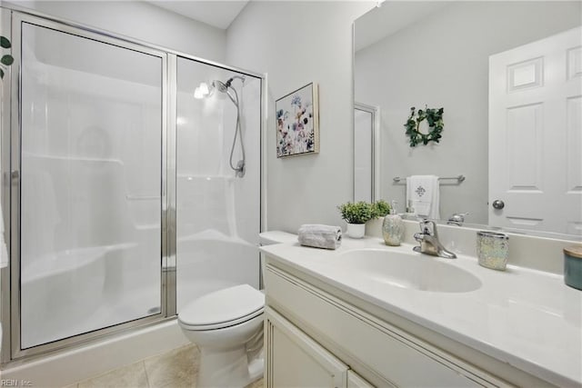 bathroom with vanity, toilet, tile patterned flooring, and a stall shower