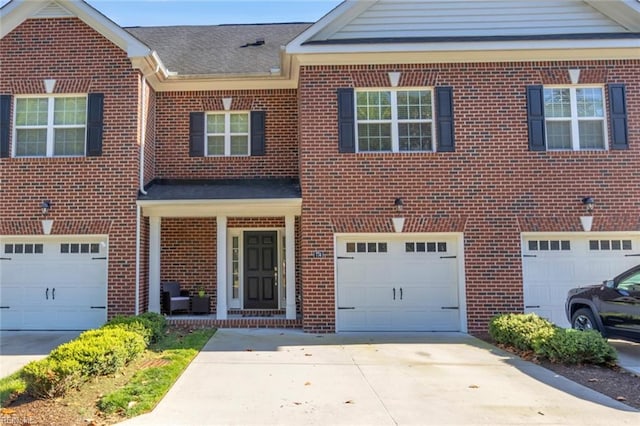 view of front facade featuring brick siding, a garage, and driveway