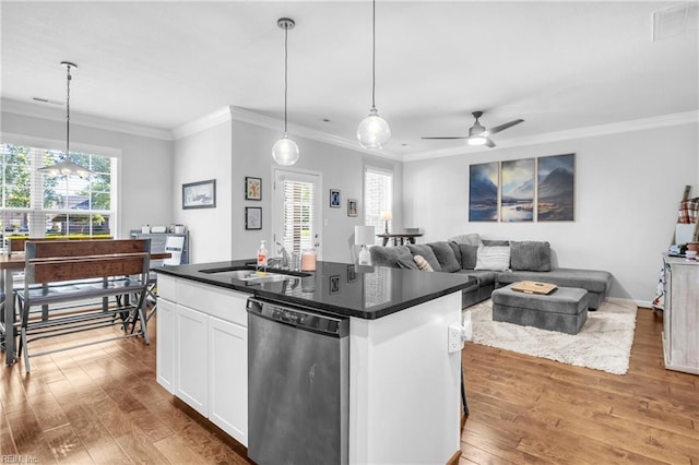 kitchen featuring wood finished floors, dark countertops, white cabinetry, a sink, and dishwasher