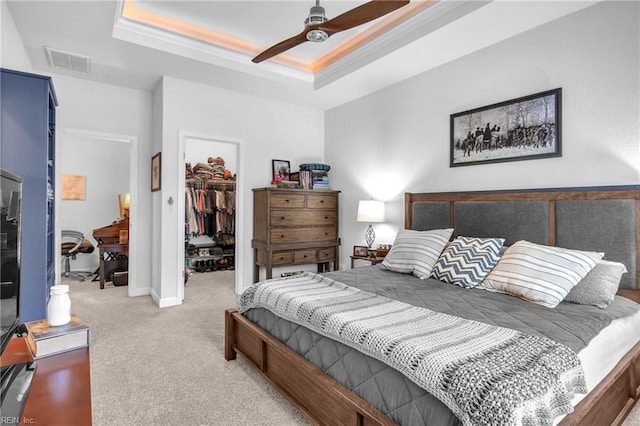 bedroom featuring carpet floors, a closet, visible vents, a raised ceiling, and a spacious closet