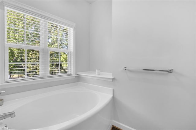 full bathroom featuring baseboards and a garden tub