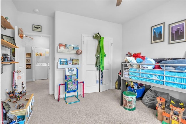 carpeted bedroom featuring a ceiling fan and washer / dryer