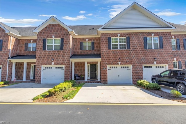 view of property featuring a garage, driveway, and brick siding