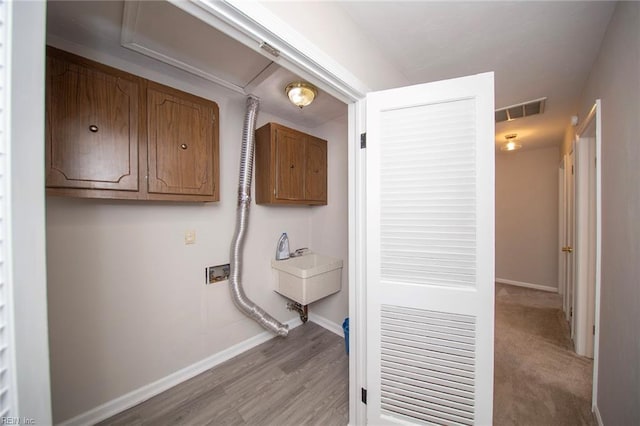 laundry area featuring baseboards, hookup for a washing machine, cabinet space, and visible vents