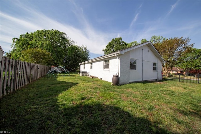 view of home's exterior with a lawn and a fenced backyard