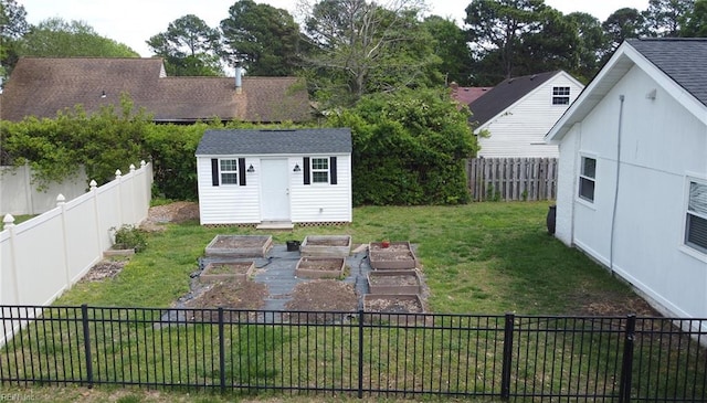 view of yard featuring a storage shed, an outbuilding, a garden, and a fenced backyard