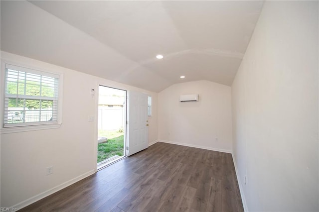 spare room featuring a wall mounted air conditioner, recessed lighting, baseboards, wood finished floors, and lofted ceiling