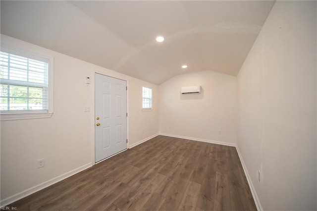 foyer with dark wood-style flooring, baseboards, recessed lighting, a wall unit AC, and vaulted ceiling