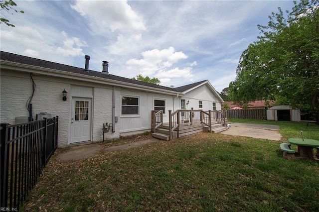 rear view of house featuring a fenced backyard, a patio, a lawn, and a shed