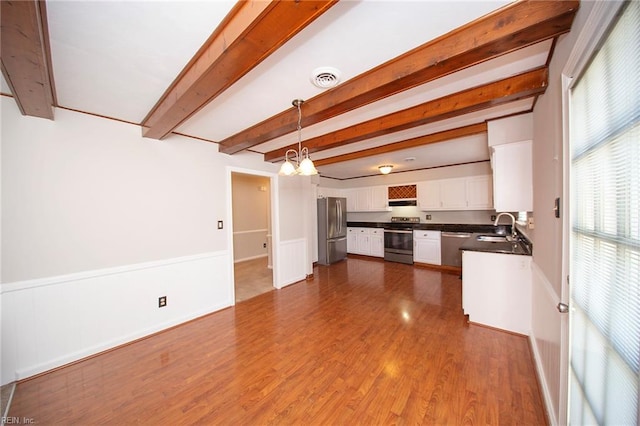 interior space with a notable chandelier, wainscoting, a sink, dark wood finished floors, and beamed ceiling