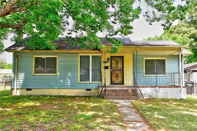 single story home with covered porch, crawl space, fence, and a front lawn