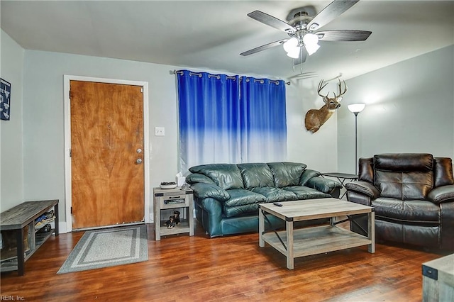 living area with a ceiling fan and wood finished floors