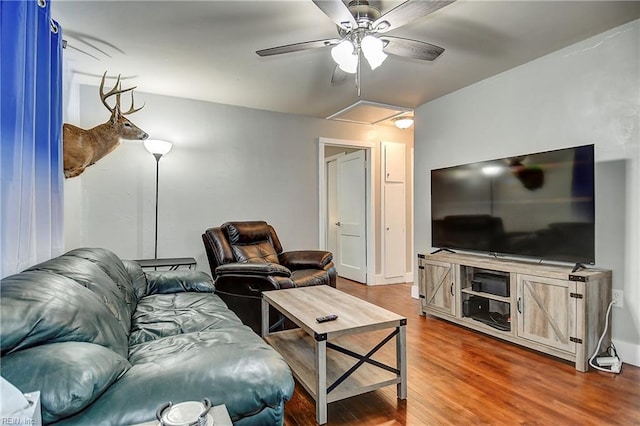 living area with a ceiling fan, attic access, and dark wood-type flooring