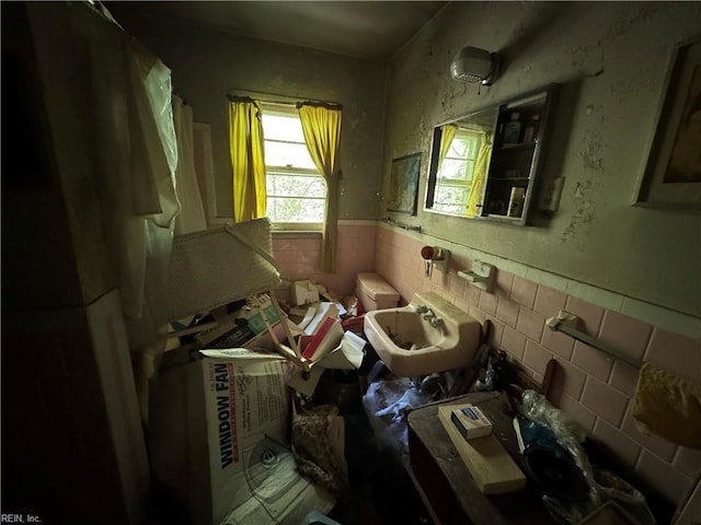 miscellaneous room featuring tile walls and a wainscoted wall