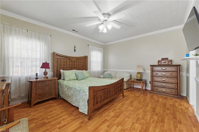 bedroom with visible vents, ornamental molding, light wood-style flooring, and a ceiling fan