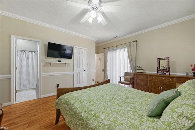 bedroom featuring crown molding, visible vents, light wood-style floors, a ceiling fan, and ensuite bath