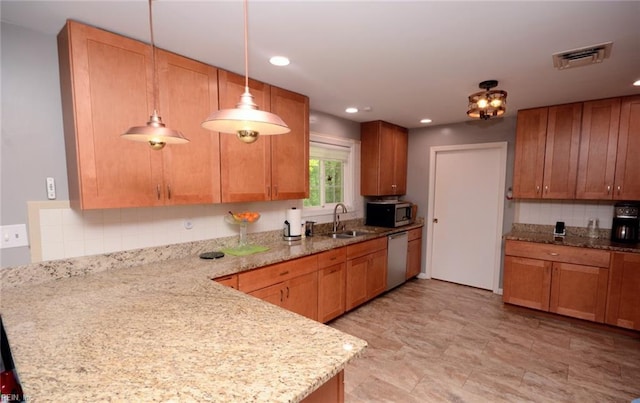 kitchen with decorative backsplash, visible vents, appliances with stainless steel finishes, a sink, and a peninsula