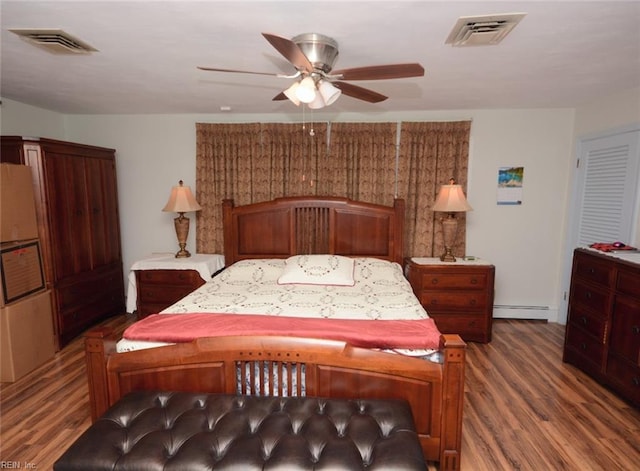 bedroom with visible vents, a ceiling fan, a baseboard heating unit, and wood finished floors