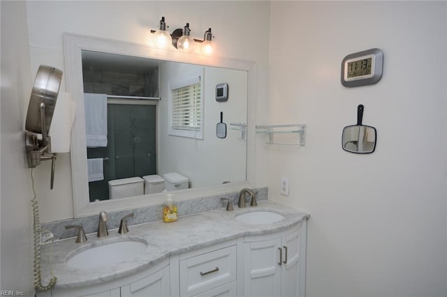 full bath with double vanity, a sink, and a stall shower
