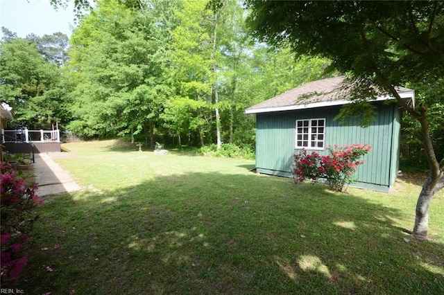 view of yard featuring a shed, an outbuilding, and a deck