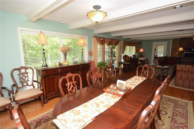 dining space featuring beam ceiling and wood finished floors