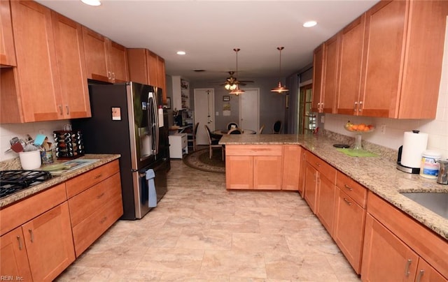 kitchen with a peninsula, ceiling fan, decorative backsplash, and stainless steel fridge with ice dispenser