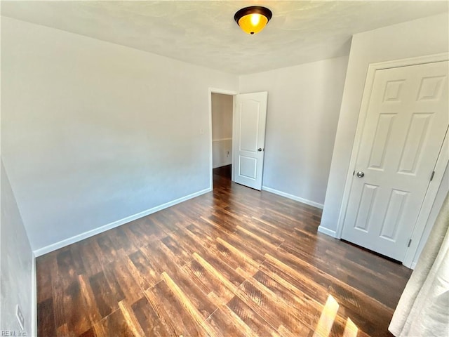 unfurnished bedroom with baseboards and wood finished floors