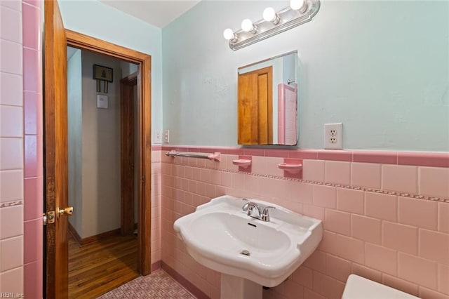 100 Hudgins Rd, Poquoson, VA 23662 - bathroom featuring wood finished floors, a sink, a wainscoted wall, and tile walls
