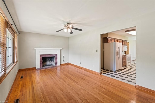 100 Hudgins Rd, Poquoson, VA 23662 - unfurnished living room with a brick fireplace, a ceiling fan, visible vents, and light wood-style flooring