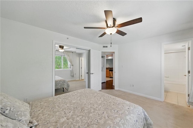 bedroom with ceiling fan, visible vents, baseboards, carpet flooring, and ensuite bath