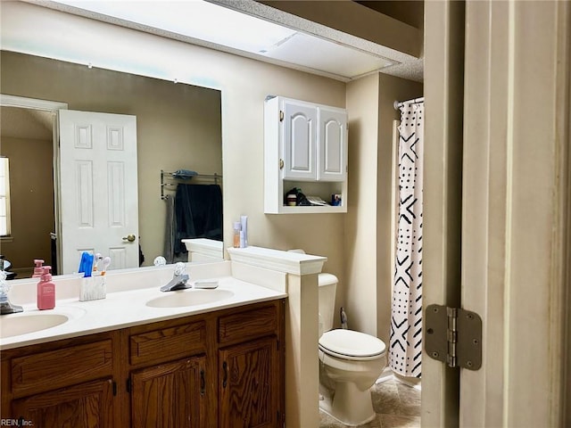 bathroom with double vanity, toilet, tile patterned floors, and a sink