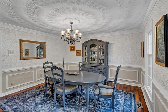 dining room with visible vents, wainscoting, wood finished floors, and a notable chandelier
