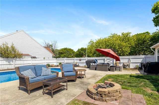 view of patio / terrace featuring a fenced in pool, a fenced backyard, and an outdoor living space with a fire pit