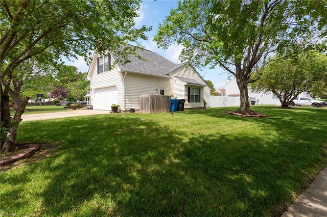 view of side of home featuring fence, roof with shingles, a garage, concrete driveway, and a lawn