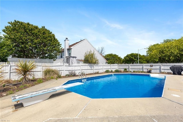 view of swimming pool with a fenced in pool, a diving board, a patio area, and a fenced backyard