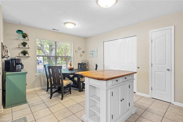 interior space featuring white cabinets, light tile patterned flooring, open shelves, wooden counters, and visible vents