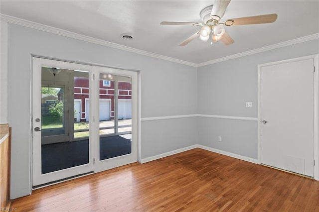 empty room featuring a ceiling fan, ornamental molding, and wood finished floors