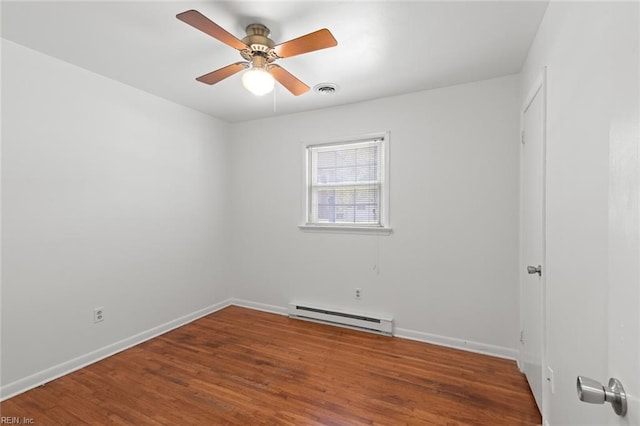 unfurnished room with visible vents, baseboards, a baseboard heating unit, and wood finished floors