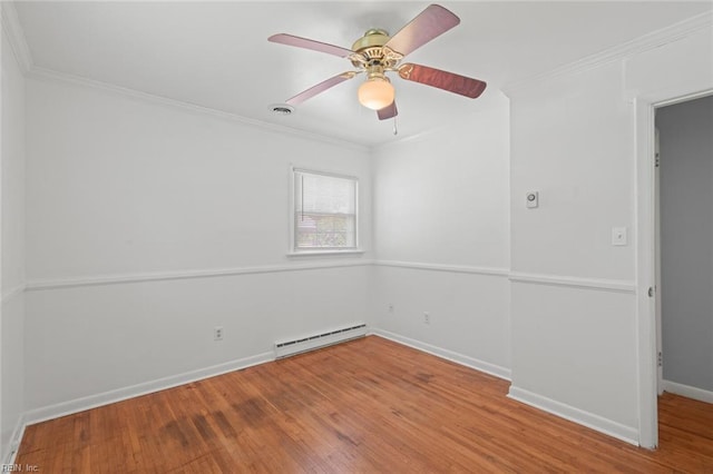 spare room with crown molding, baseboards, wood finished floors, and a baseboard radiator