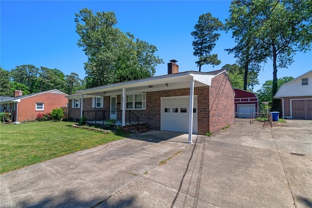 ranch-style home featuring a chimney, a front yard, a garage, brick siding, and concrete driveway