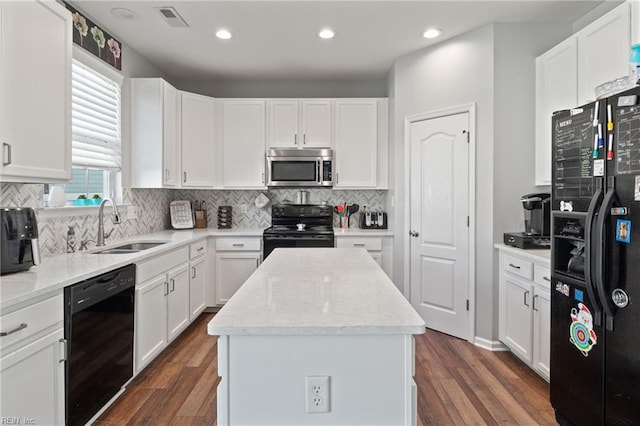 kitchen with a sink, a center island, white cabinetry, visible vents, and black appliances