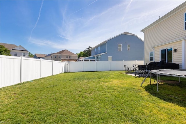 view of yard with a fenced backyard, a trampoline, and a patio