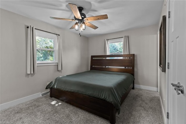 carpeted bedroom featuring baseboards, a ceiling fan, and multiple windows