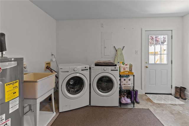 laundry room with a sink, laundry area, washing machine and dryer, and electric water heater