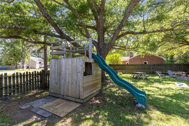 view of jungle gym with a yard, a fire pit, and a fenced backyard