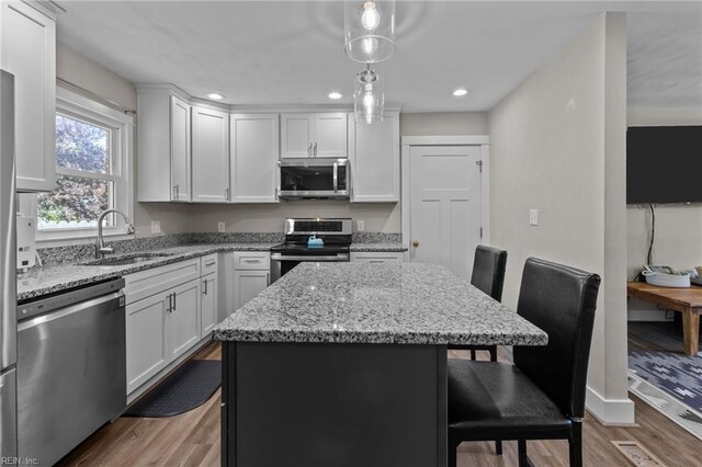 2600 Smithson Dr, Chesapeake, VA 23322 - kitchen with wood finished floors, a kitchen breakfast bar, a center island, a sink, and stainless steel appliances